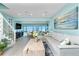 Light and airy living room features a large gray sofa, wood coffee table, and adjacent dining area with water views at 2955 N Beach Rd # D123, Englewood, FL 34223