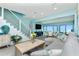 Bright living room features a staircase with rope railing, a gray sofa, and water views from the adjacent dining area at 2955 N Beach Rd # D123, Englewood, FL 34223
