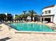 Community pool with sun loungers, palm trees, and a nearby building on a sunny day at 2955 N Beach Rd # D123, Englewood, FL 34223