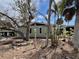 Charming exterior with mature trees and landscaping, and light green siding giving it a welcoming appeal at 2985 N Beach Rd # Bv-5, Englewood, FL 34223