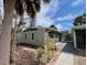 View of the home's exterior with painted light green siding, featuring a well-maintained yard and a covered carport at 2985 N Beach Rd # Bv-5, Englewood, FL 34223