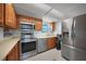 Spacious kitchen with stainless appliances, wooden cabinetry, recessed lighting, and tile floor at 311 Garvin St # 209C, Punta Gorda, FL 33950