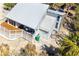 Aerial view of home with deck, white metal roof, and tropical foliage at 4078 N Beach Rd, Englewood, FL 34223