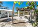 Backyard featuring a pergola-covered lounge area with a fire pit, perfect for relaxing by the beach at 4078 N Beach Rd, Englewood, FL 34223