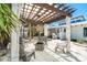 Backyard with a pergola over a fire pit and seating area perfect for outdoor entertaining and relaxing at 4078 N Beach Rd, Englewood, FL 34223