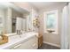 Well-lit bathroom with a stylish vanity, a framed mirror, and a shower with a neutral-toned tile surround at 4078 N Beach Rd, Englewood, FL 34223