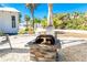 Outdoor fire pit with stone surround and Adirondack chairs on sandy yard at 4078 N Beach Rd, Englewood, FL 34223