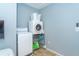 Functional laundry room equipped with a washer, dryer, and shelving for convenient storage of supplies at 4078 N Beach Rd, Englewood, FL 34223