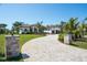 Paver driveway leading to a modern home with meticulously maintained landscaping and a welcoming entrance at 425 Spaniards Rd, Placida, FL 33946
