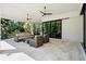 Covered patio with ample seating and a ceiling fan provides a view of the lush backyard at 425 Spaniards Rd, Placida, FL 33946