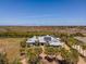 Expansive aerial view of the home showcasing its lush surroundings, solar panels, and outdoor living spaces at 50 Spyglass Aly, Placida, FL 33946