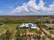 Expansive aerial view of a beautiful one-story home with solar panels, lush greenery, and a serene waterfront backdrop at 50 Spyglass Aly, Placida, FL 33946