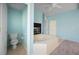 Bright bathroom features a jacuzzi tub with a fireplace, toilet, and tiled floors at 50 Spyglass Aly, Placida, FL 33946