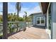 Outdoor deck with a light blue railing leads to a home with double doors, surrounded by lush tropical vegetation at 50 Spyglass Aly, Placida, FL 33946