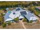 An eye-level aerial view of the light-blue home's roof, pool, and palm trees at 50 Spyglass Aly, Placida, FL 33946