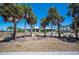 Inviting single-story residence shaded by mature palm trees, enhanced by lush landscaping and a well-manicured lawn at 50 Spyglass Aly, Placida, FL 33946