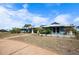 Charming single-story home with a light blue exterior, solar panels, lush landscaping, and a long driveway at 50 Spyglass Aly, Placida, FL 33946
