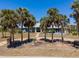Charming home featuring a light blue exterior, concrete drive, and enhanced curb appeal thanks to mature landscaping at 50 Spyglass Aly, Placida, FL 33946