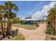 Inviting one-story home with a metal roof and solar panels, surrounded by palm trees and a circular driveway at 50 Spyglass Aly, Placida, FL 33946