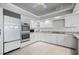 This modern kitchen has sleek, white cabinets, stainless steel appliances, and tile flooring at 50 Spyglass Aly, Placida, FL 33946