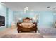 Spacious main bedroom boasts custom bed frame, natural light, and soft blue walls at 50 Spyglass Aly, Placida, FL 33946