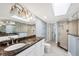 A bathroom featuring a glass-enclosed shower, marble countertop with double sinks and a skylight at 5000 Gasparilla Rd # 41B, Boca Grande, FL 33921