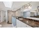 Spacious bathroom featuring double sinks, a skylight, and a glass-enclosed shower with dark countertops at 5000 Gasparilla Rd # 41B, Boca Grande, FL 33921