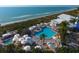An inviting resort-style pool area with lounge chairs, umbrellas, a spa, and beach access at 5000 Gasparilla Rd # 41B, Boca Grande, FL 33921