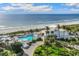 Aerial view showcasing a pristine beachfront property with a pool, palm trees, and panoramic ocean vistas at 5000 Gasparilla Rd # Vh37, Boca Grande, FL 33921