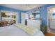 This bedroom boasts blue walls, balcony access, a dresser, and an en-suite bathroom at 5000 Gasparilla Rd # Vh37, Boca Grande, FL 33921