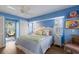 Cozy bedroom featuring blue walls, plantation shutters, balcony access and comfortable furnishings at 5000 Gasparilla Rd # Vh37, Boca Grande, FL 33921