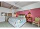 Charming bedroom with a pink accent wall, floral bedding, and a bright, airy feel, creating a comfortable retreat at 5000 Gasparilla Rd # Vh37, Boca Grande, FL 33921