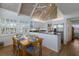 Dining area features a wood table set for six, a vaulted ceiling, and an open kitchen with stainless appliances at 5000 Gasparilla Rd # Vh37, Boca Grande, FL 33921