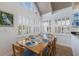 Bright dining room features a wood table set for six, a vaulted ceiling, and natural light from plantation shutters at 5000 Gasparilla Rd # Vh37, Boca Grande, FL 33921
