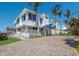 Expansive home with a bright blue awning, large windows, and a welcoming brick driveway at 5000 Gasparilla Rd # Vh37, Boca Grande, FL 33921