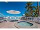Pool area with jacuzzi, lounge chairs, umbrellas, and beautiful landscaping create a resort-style oasis at 5000 Gasparilla Rd # Vh37, Boca Grande, FL 33921
