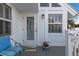 Inviting porch featuring a cushioned chair, a floral accent, and a charming doorway at 5000 Gasparilla Rd # Vh37, Boca Grande, FL 33921