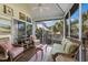 Bright sunroom with comfortable wicker furniture, ceiling fan, and view of palm trees and the neighborhood at 5000 Gasparilla Rd # Vh37, Boca Grande, FL 33921