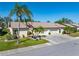 Exterior view of the property, showcasing the front lawn, two-car garage, and well-manicured landscaping at 544 Foxwood Blvd, Englewood, FL 34223