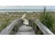 Pathway to the beach through coastal grasses and greenery, providing a serene escape at 5800 Gulf Shores Dr # 33, Boca Grande, FL 33921