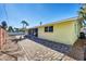 Backyard of home has a stone patio surrounded by a yellow house at 6035 Manasota Key Rd, Englewood, FL 34223