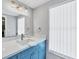 Modern bathroom featuring a vanity with a blue cabinet, a stylish faucet, and a large mirror at 6035 Manasota Key Rd, Englewood, FL 34223