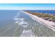 Aerial view of expansive sandy beach, ocean, and shoreline with calm waves and lush vegetation at 6035 Manasota Key Rd, Englewood, FL 34223