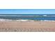 Scenic beach view of soft, sandy shore and clear blue ocean water with gentle waves at 6035 Manasota Key Rd, Englewood, FL 34223