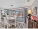Cozy dining area featuring a round table, stylish decor, and sliding glass doors leading to a screened outdoor space at 6035 Manasota Key Rd, Englewood, FL 34223