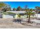 Charming single story home with attached garage, lush lawn and tropical landscaping and trees at 6035 Manasota Key Rd, Englewood, FL 34223