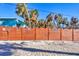 Newly stained wood fence creating a private backyard space surrounded by palm trees at 6035 Manasota Key Rd, Englewood, FL 34223