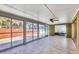 Spacious sunroom with tile flooring, fan, and glass windows looking onto the outdoor patio at 6035 Manasota Key Rd, Englewood, FL 34223