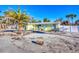 Inviting home exterior featuring a well-kept lawn, mature palm trees and a fenced yard at 6035 Manasota Key Rd, Englewood, FL 34223