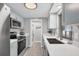 Bright kitchen with stainless steel appliances, white countertops, and light blue cabinets at 6035 Manasota Key Rd, Englewood, FL 34223